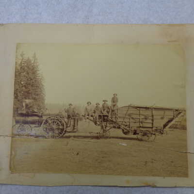 Steam Tractor pulling farm trailer men sitting on it
