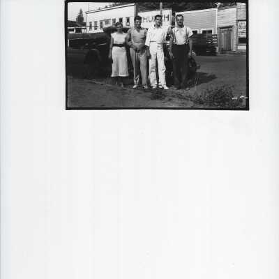 four persons standing by a car