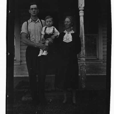 Man, Woman, and Child in Front of House