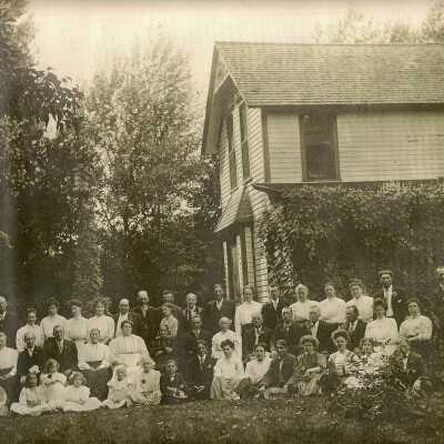 Unknown large family shot in front of house.