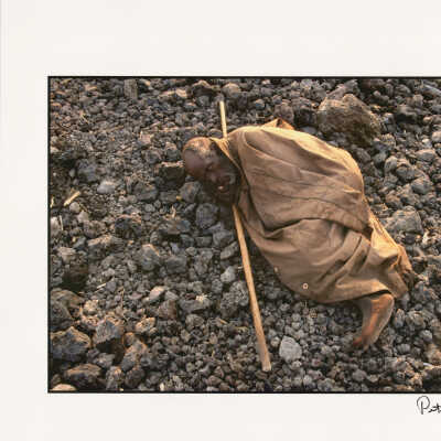 Rwandan Hutu refugee lies on the rocky ground of a refugee camp, during the Rwandan genocide crisis of 1994. Goma, Zaire