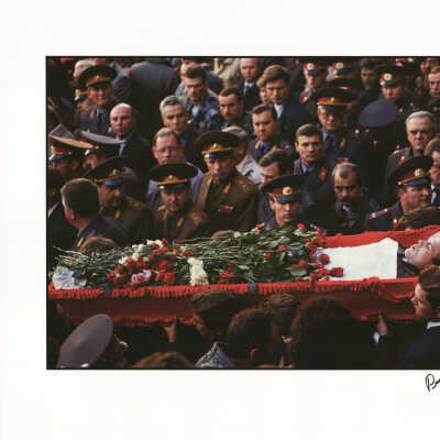 The flower-covered body of a soldier who was killed during the violent conflict at the Russian White House in October 1993 is carried past a group of officers and other mourners at a funeral.