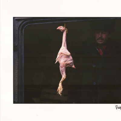 A vendor sells a plucked chicken at a street market, Moscow, Russia