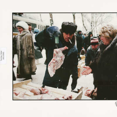 Street vendor weighs piece of poultry for his customer, Moscow, Russia