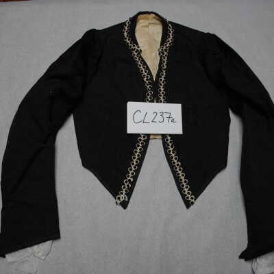 Waist trimmed with white braid with black dots