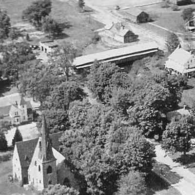2023.21.1.2 Aerial view of Sinnott Gas Station 1940's (upper left) with Shelburne Museum covered bridge to the right, circa 1954.