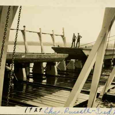 Two men on a barge sitting in the carrgiage giving the scale of the project.