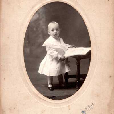 Portrait of a Child Standing by a Low Table