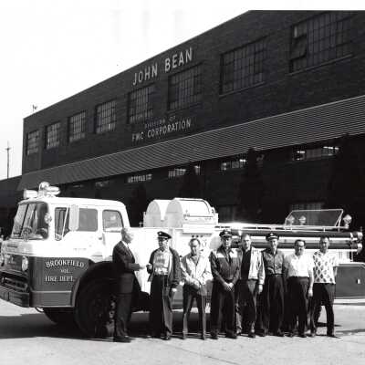 Firemen with Firetruck in Front of John Bean Building