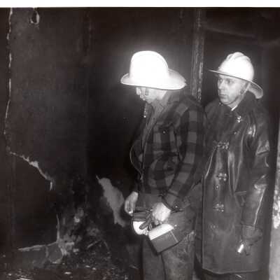 Firemen Walking Through Burnt Building