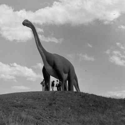 People under a dinosaur [SIMILAR #369]