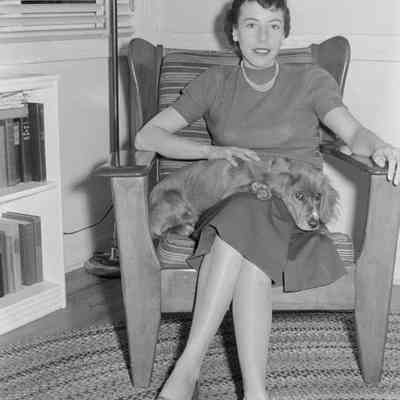 Woman on chair with awake dog