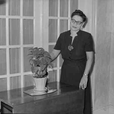 Woman next to a house plant