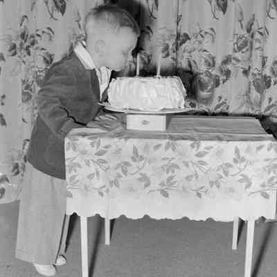 Little boy smelling cake