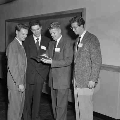Four men looking at a book
