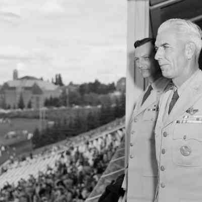 Uniformed men watching football