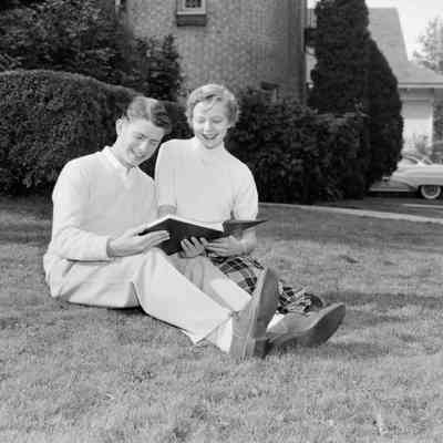 Looking at a book on the lawn