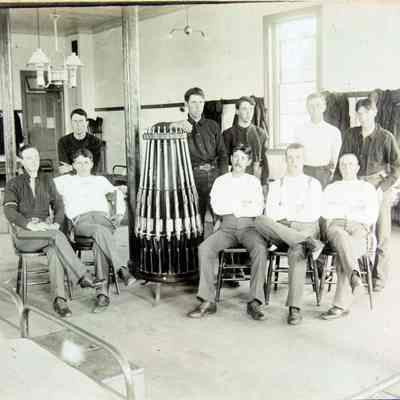10 men in barracks around rifle rack
