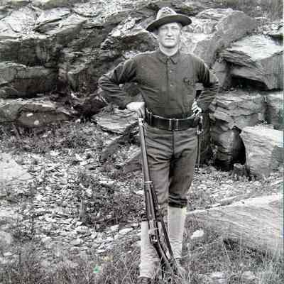 Standing male with rifle outside