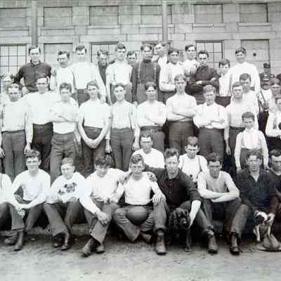 Company group portrait outside set against housing