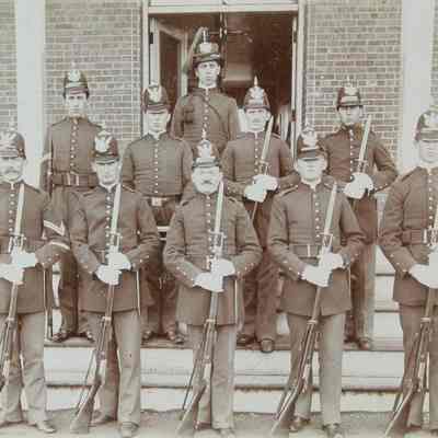 10 males in uniform standing on steps