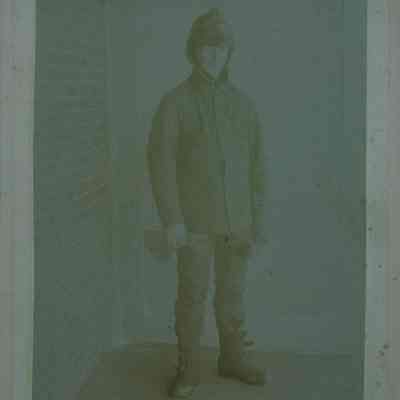 Standing male in winter clothing holding gloves