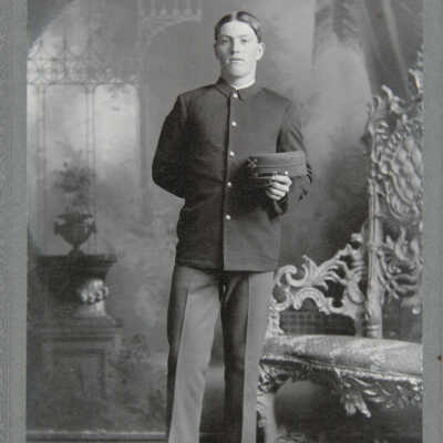 Portrait, full figure standing male in uniform holding hat