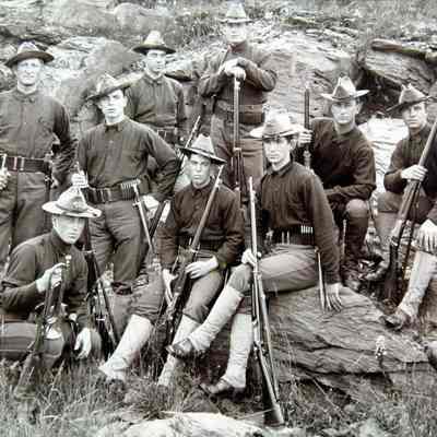 9 men in uniforms on rock outcropping