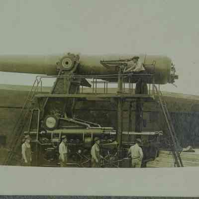 Men turning artillery cannon