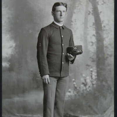 Portrait, male, standing full figure, wearing uniform holding hat