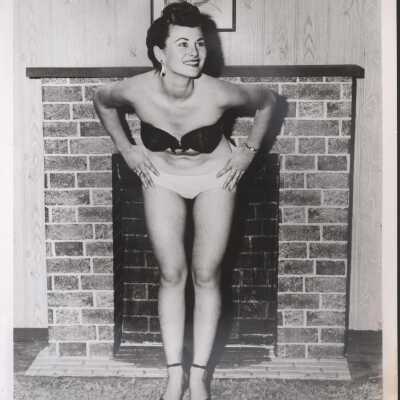 Photo - Dona Hunter writen on back B&W bra & panty posed in front of fireplace "S&S Film productions