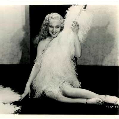 Photo - Sally Rand-Sitting on ground holding a fan-B&W