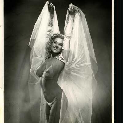 Photo - Taffy O'Neil-B&W-Sheer Bra and Panties-Pasties under Bra-Sleeves-Holding up sheet fabric.