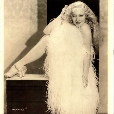 Photo - Sally Rand- Stock card- B&W sitting on a box with a large fan covering her torso