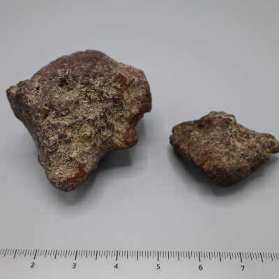 Two greyish and pink rocks with pitted surfaces