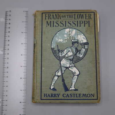 Hardback book with pale turquoise cover. Image of young man in white uniform with puttees, cap, binoculars, and rifle