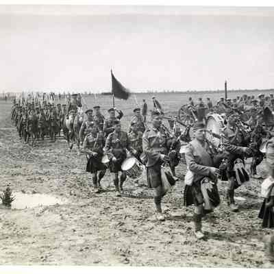 Photograph "PPCLI troops marching behind the pipe band with their Colours".