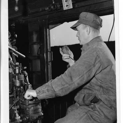 A Canadian National Engineer Speaking on a Radio in a Steam Engine Cab