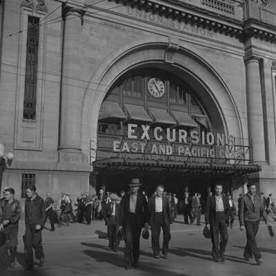 Photograph, Crowd of Men Leaving Canadian National Railways Union Station at the Excursions East and Pacific Coast Door, Winnipeg, 1940's.