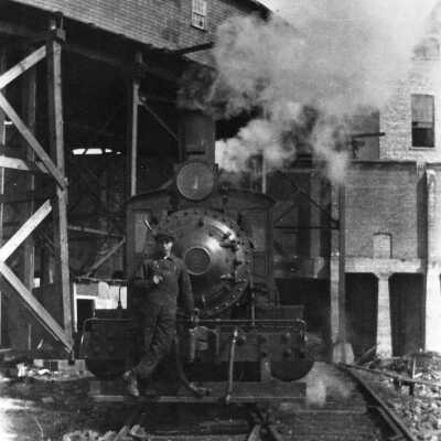 Photograph - Man posing in front of locomotive
