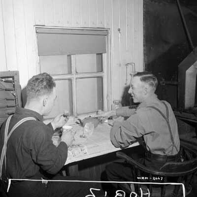 Photograph, Brakeman F.W. Gibson and another employee eat breakfast in a railway caboose at 3 a.m.