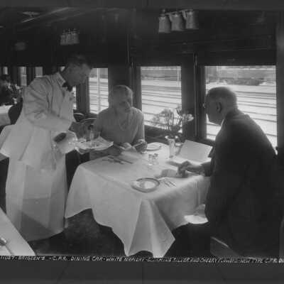 Photograph, Canadian Pacific Railway dining car, white napiery, gleaming silver and cheery flowers, 1920's.