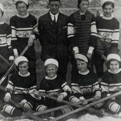 Canadian Girls In Training Hockey Team, 1932. Left to right: Dulcie Studer, Freda Adair, Millie Deavy (Thomas), Enid Studer (Mohns), Phyllis Stoddart, Frances Tye (Plexman), Coach Neil Young, Isobel Kilgour, Bernice Boyd, Dot Boyd (Meehan), Marion Deavy, Emma Nepitt (Kilgour), Helen Nepitt (Rivers).