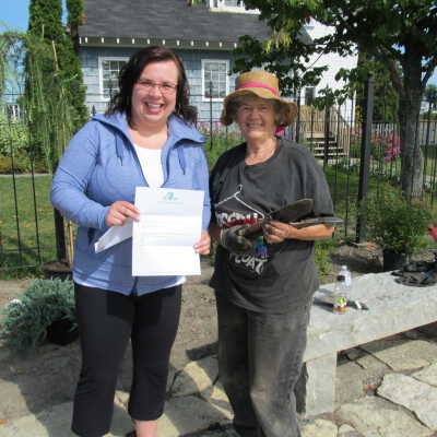 Photograph, Kirstie Conron (Manager) and Romaine Chappell (Director)with donation from Irish Heritage Club of Sudbury donation for Garden.