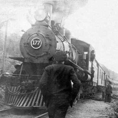 Photograph, Man standing in front of railway engine 177.