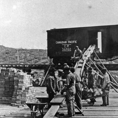 Photograph - Group of men unloading stone from a Canadian Pacific railroad car