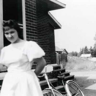 Photograph, Lozia Doucette with Bicycle at Alderdale Section House.