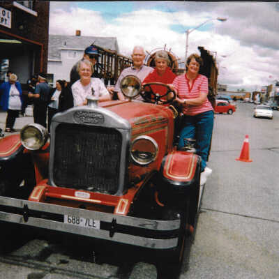 Photograph: Five people posing with the 1923 Bickle outside of the Capreol Firehall