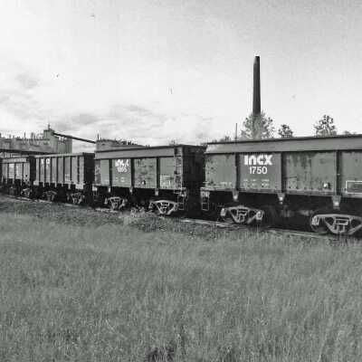 Photograph - Train on the tracks, smoke stack in background