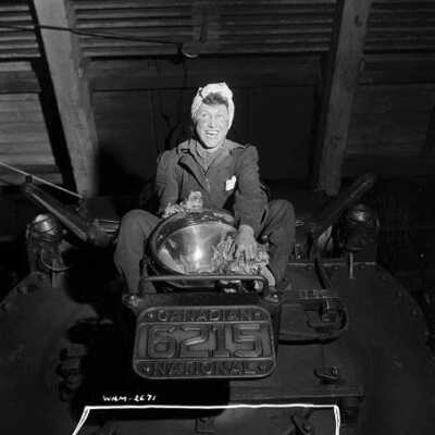 Photograph, Female worker polishes railway light in a Canadian National Railways plant.